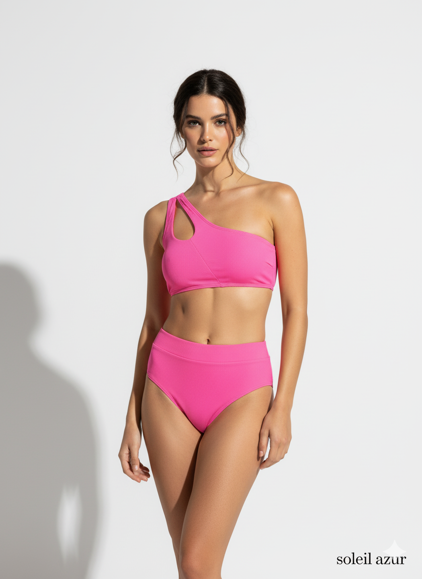 A model posing on white backdrop in pink swimwear