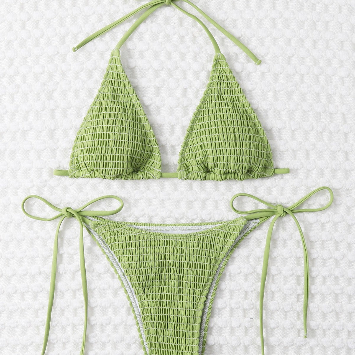 Green bikini set on a textured white background