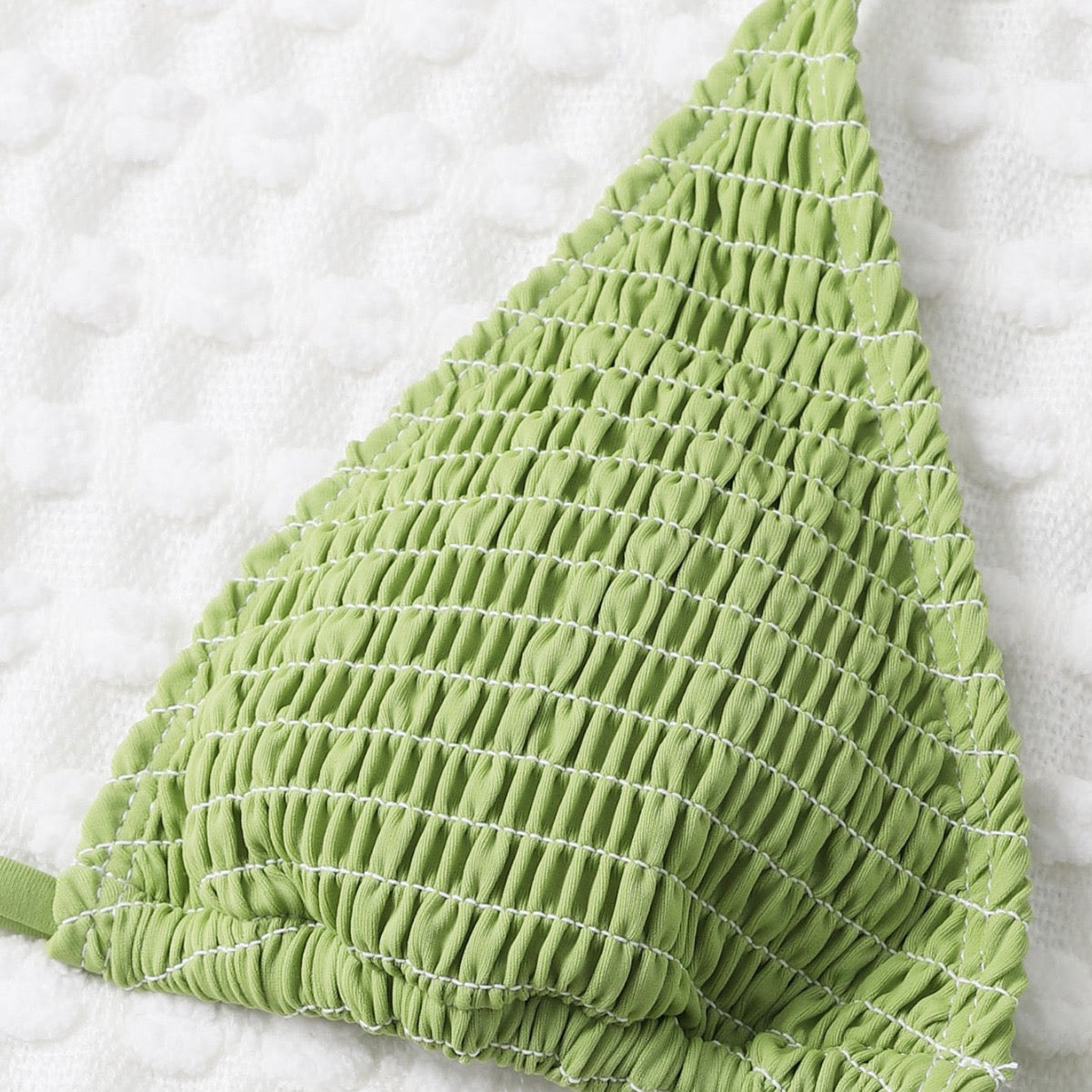 Green textured triangle-shaped object on a white background