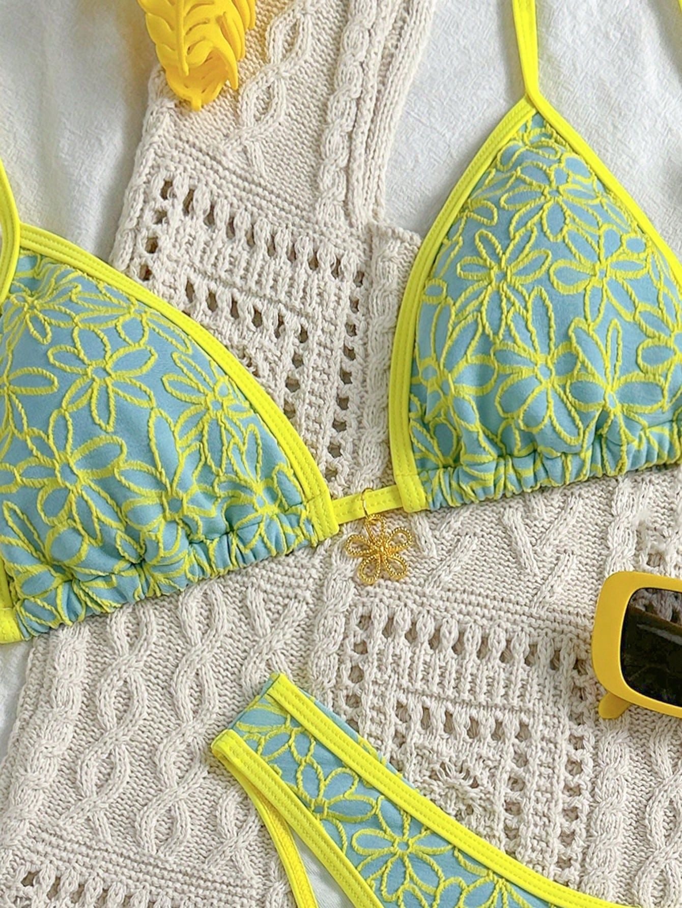 Blue and yellow bikini set on a textured white surface