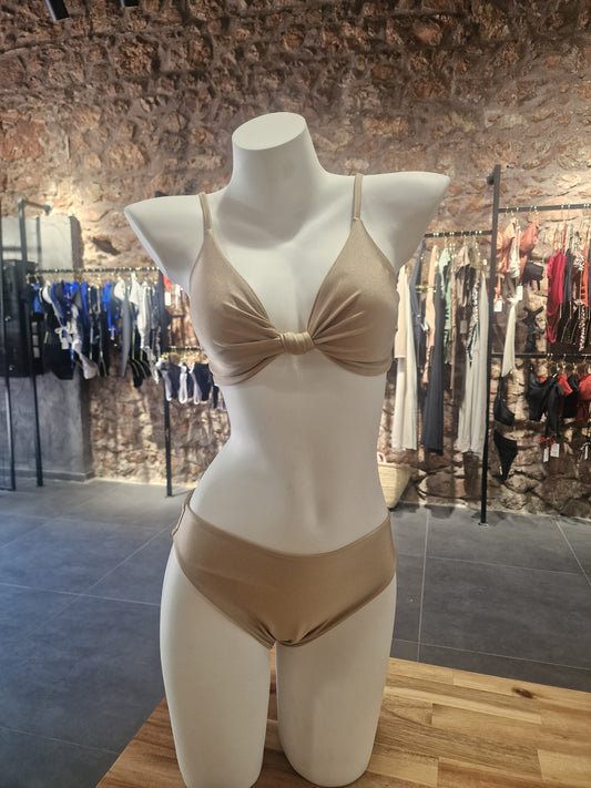 Mannequin wearing a beige dress with a bow in a store setting

