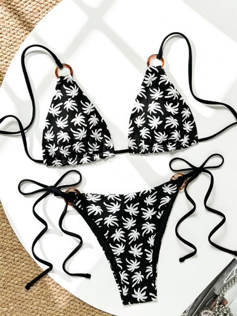  Black and white palm leaf bikini set on a white surface

