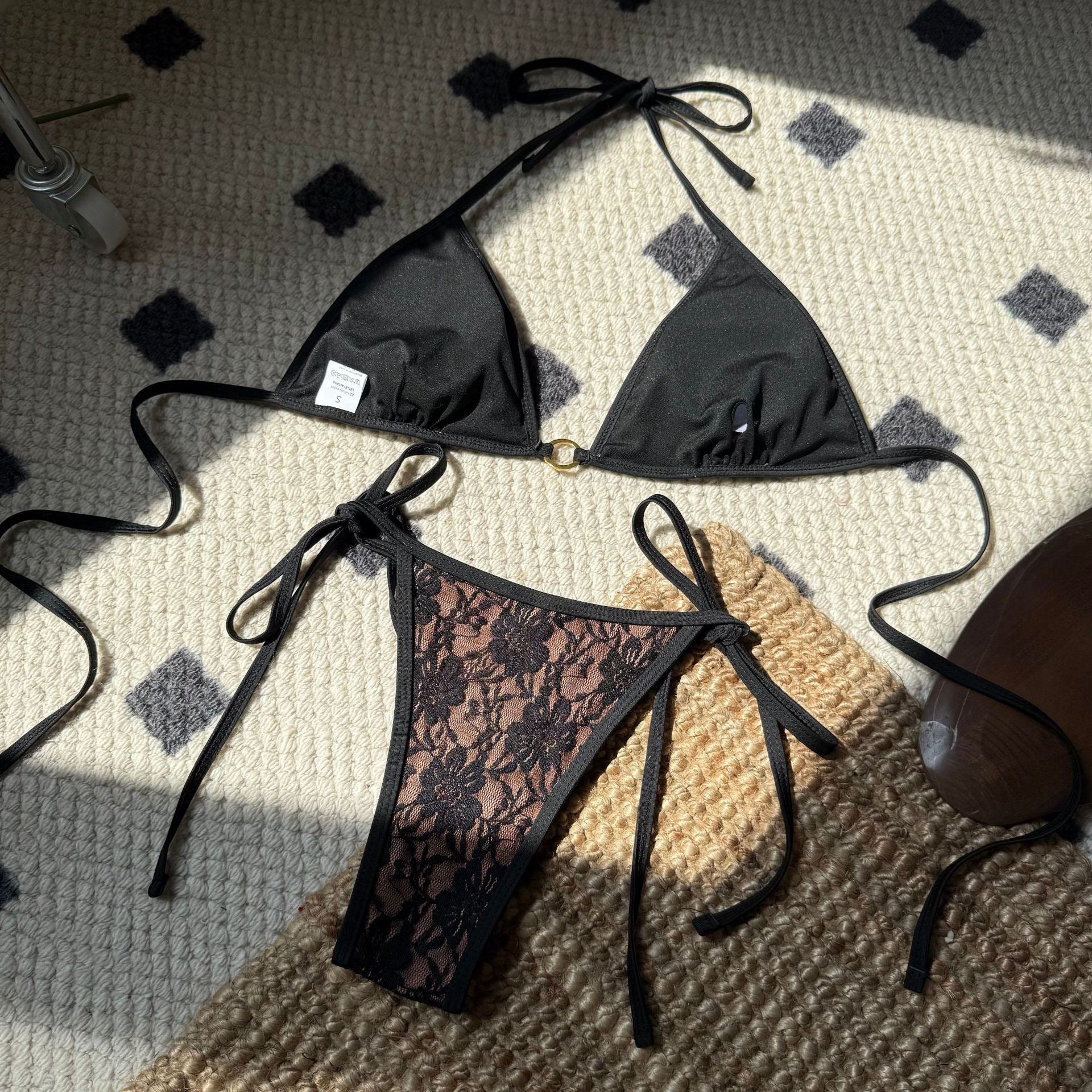 Black lace bikini set on a textured surface

