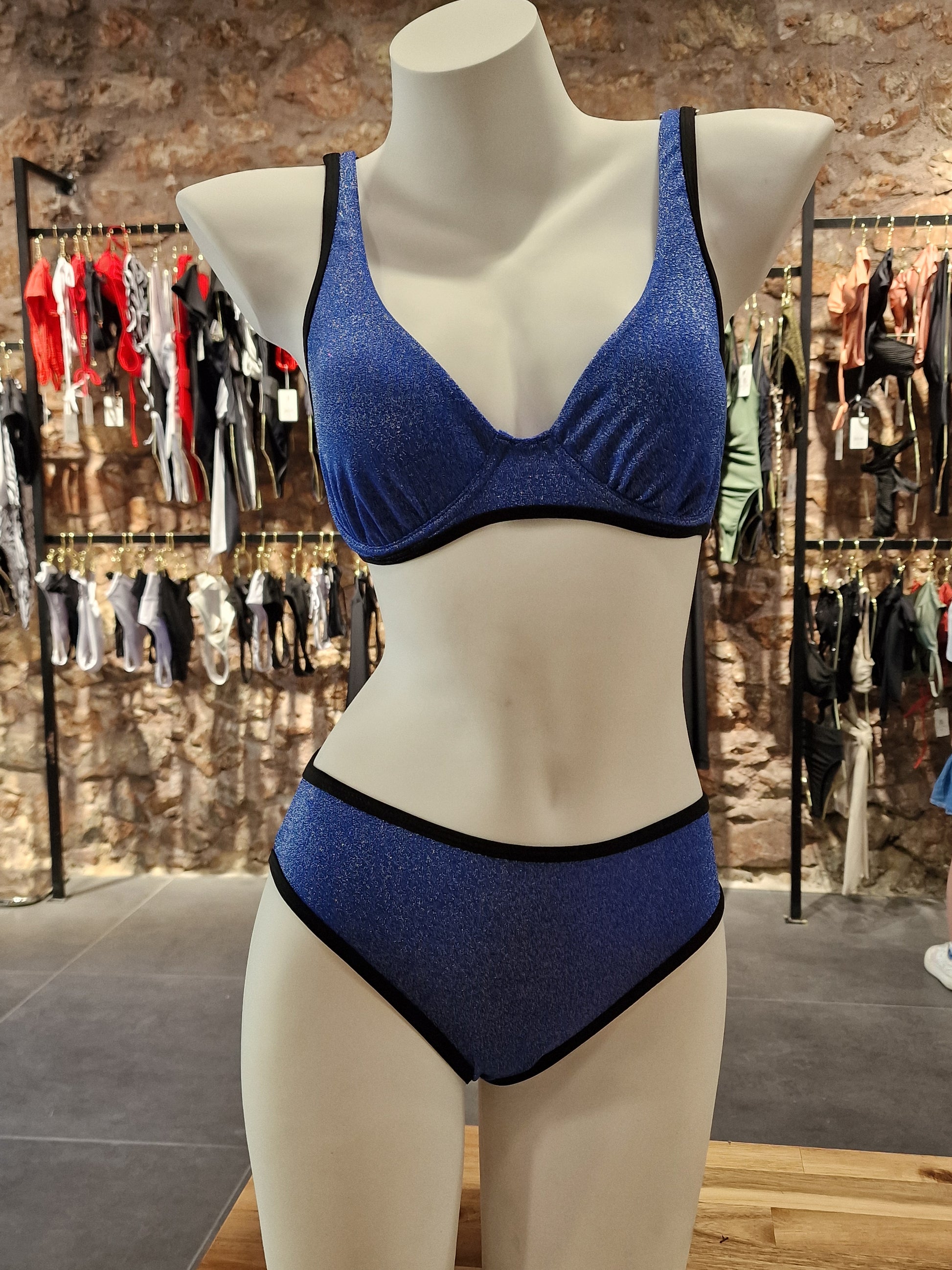 Blue bra on a mannequin with a blurred store background

