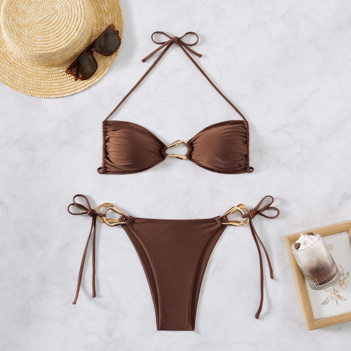 Brown bikini set with matching hat and sunglasses on a light background

