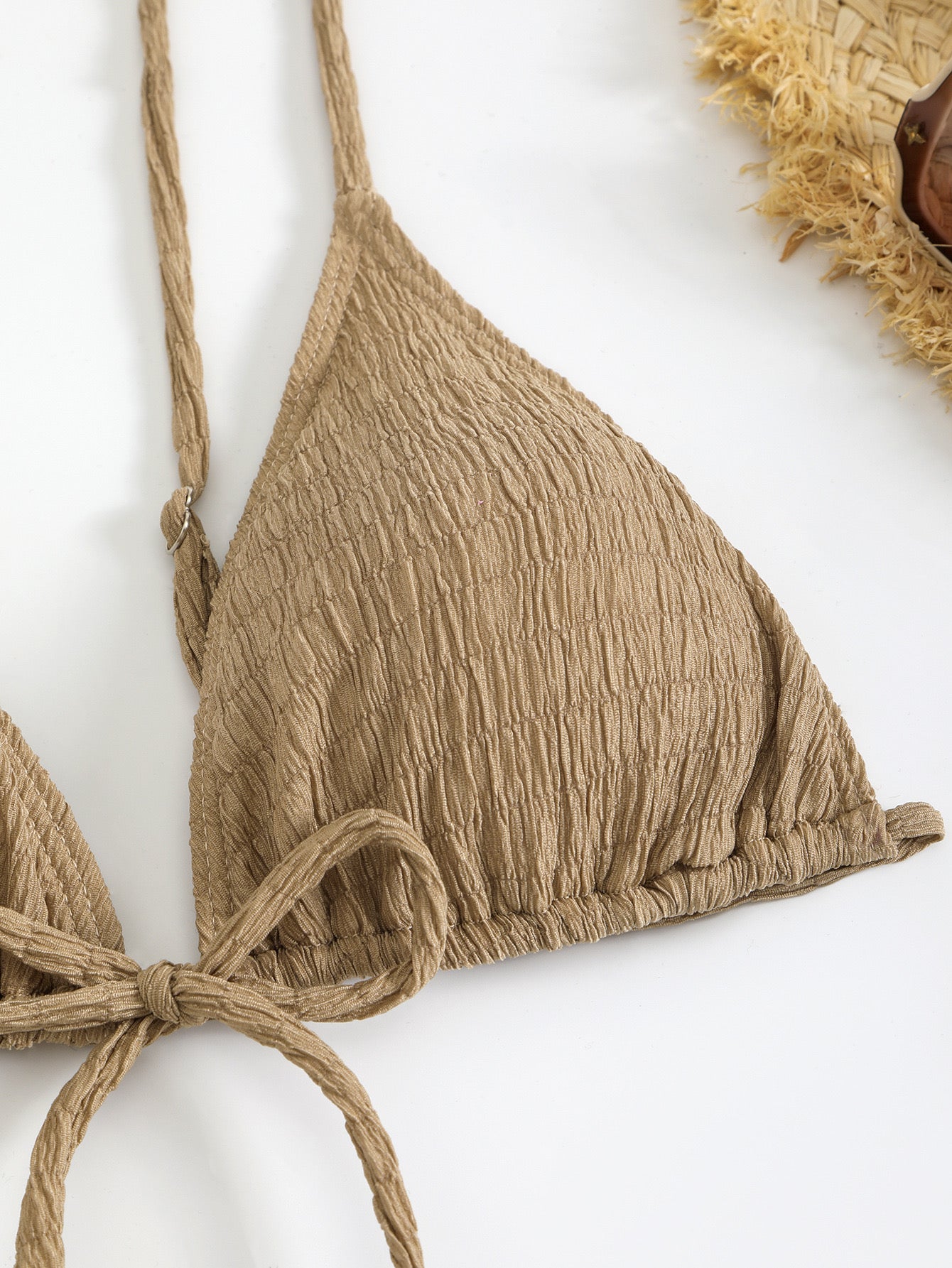 Brown bikini top with crinkled texture on a white background

