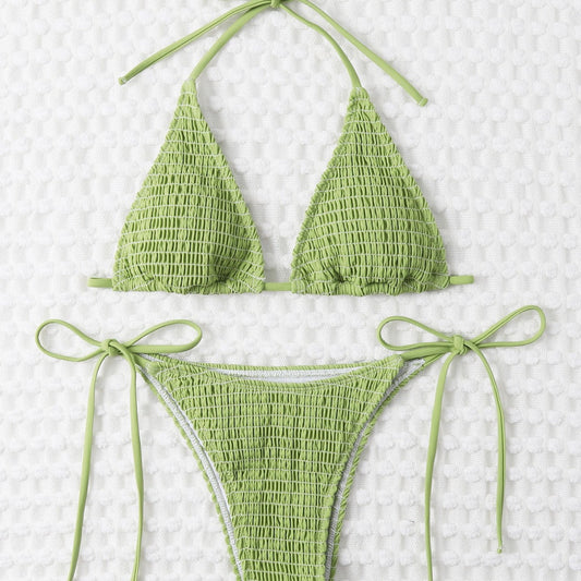 Green bikini set on a textured white background

