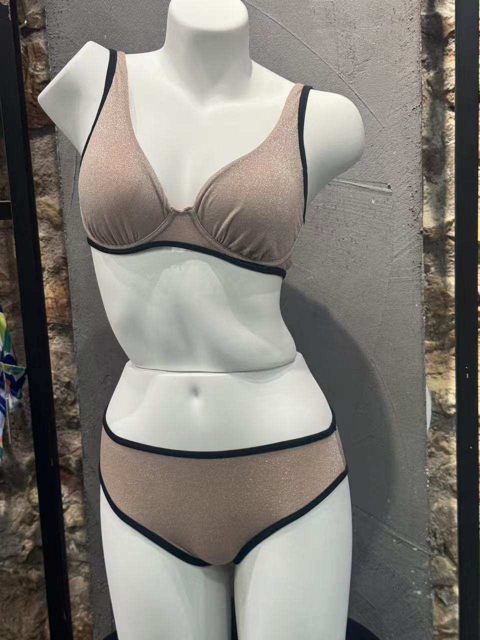 Mannequin wearing a beige bra and panties set against a neutral background

