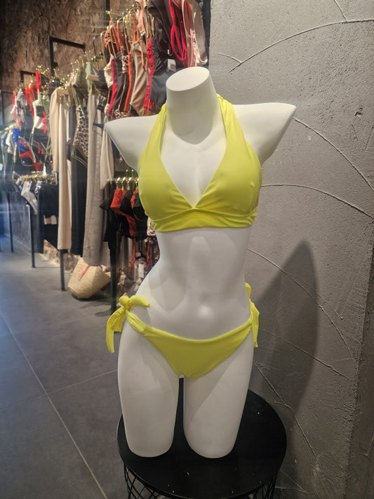 Mannequin wearing a yellow bikini on a tiled floor