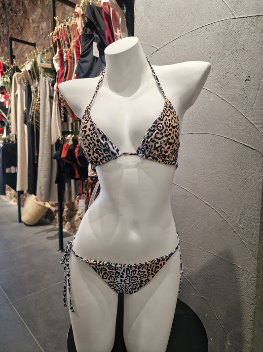 Mannequin wearing leopard print underwear on a textured surface

