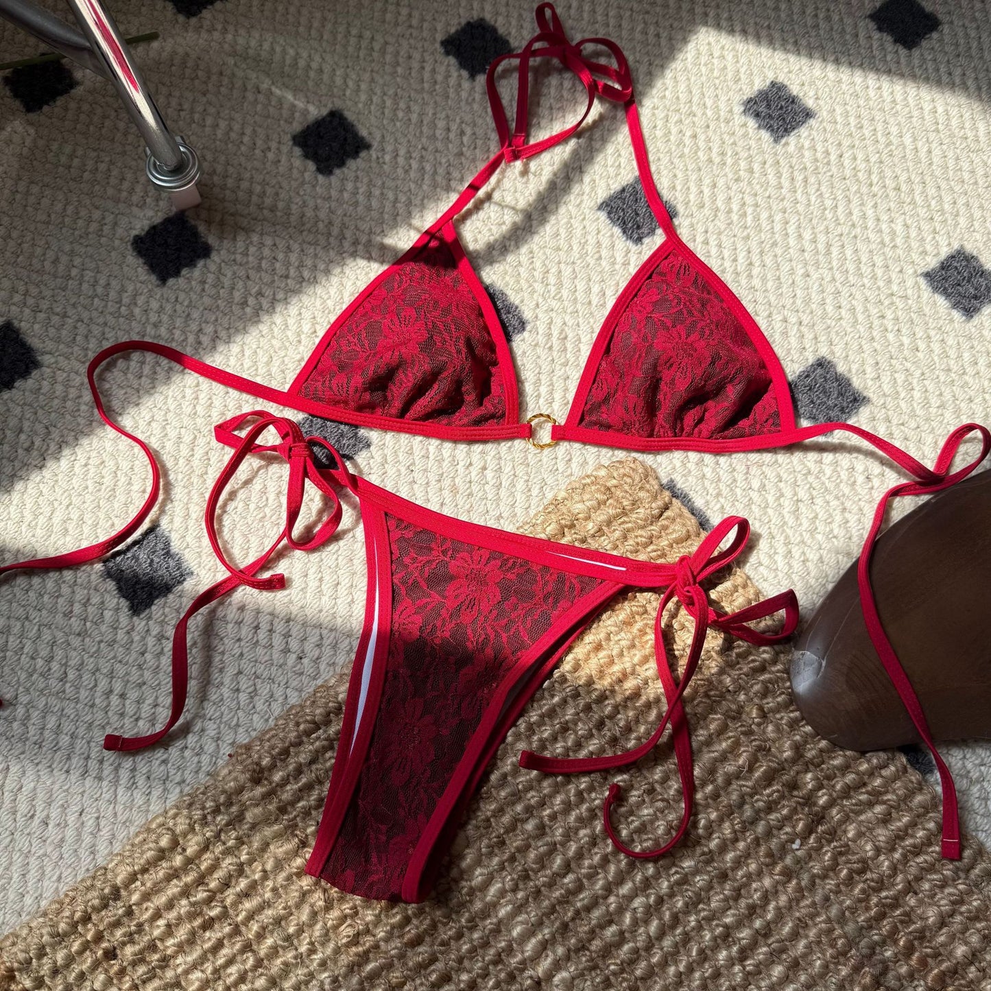 Red lace bikini set on a textured surface

